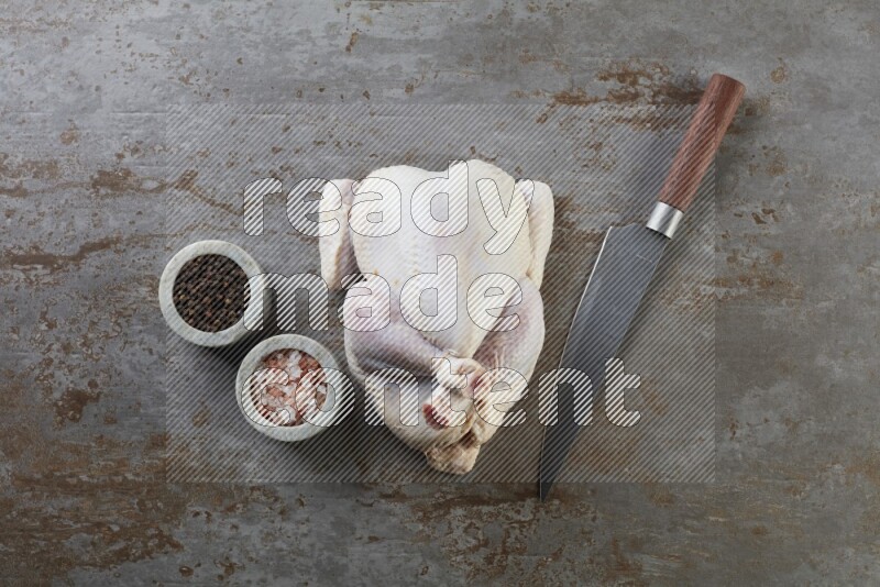 whole raw chicken  direct on a rustic grey background