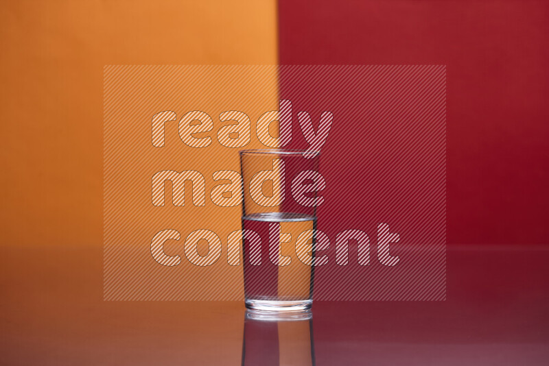 The image features a clear glassware filled with water, set against orange and red background