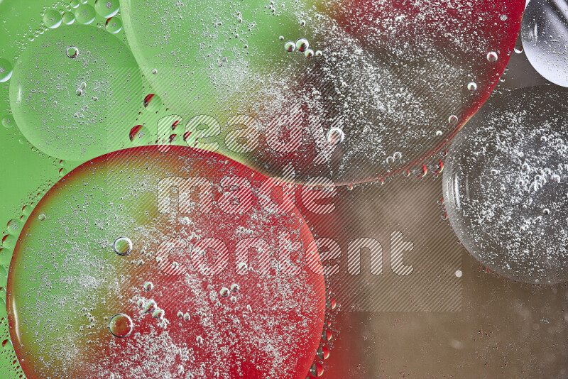 لقطات مقربة لفقاعات من الزيت على سطح الماء باللون البني والأخضر والأحمر