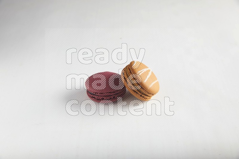 45º Shot of of two assorted Brown Irish Cream, and Red Cherry macarons on white background