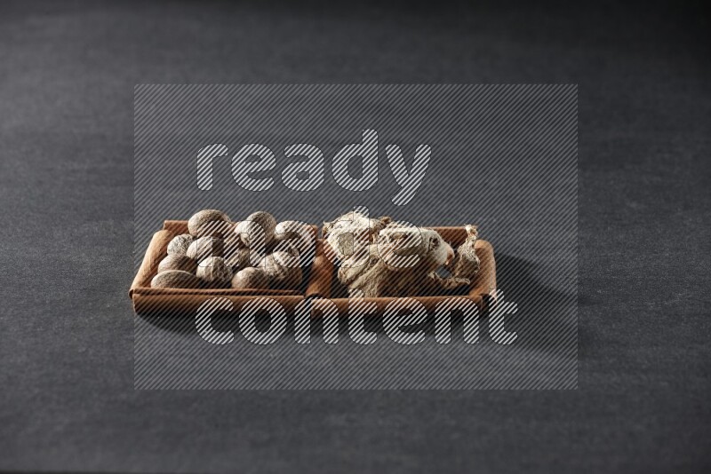 2 squares of cinnamon sticks full of nutmeg and dried ginger on black flooring