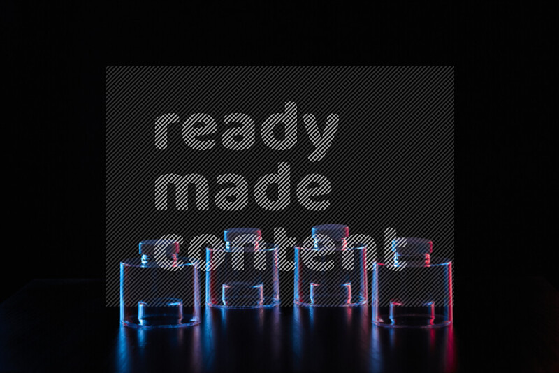 Glassware with rim light in red and blue against black background