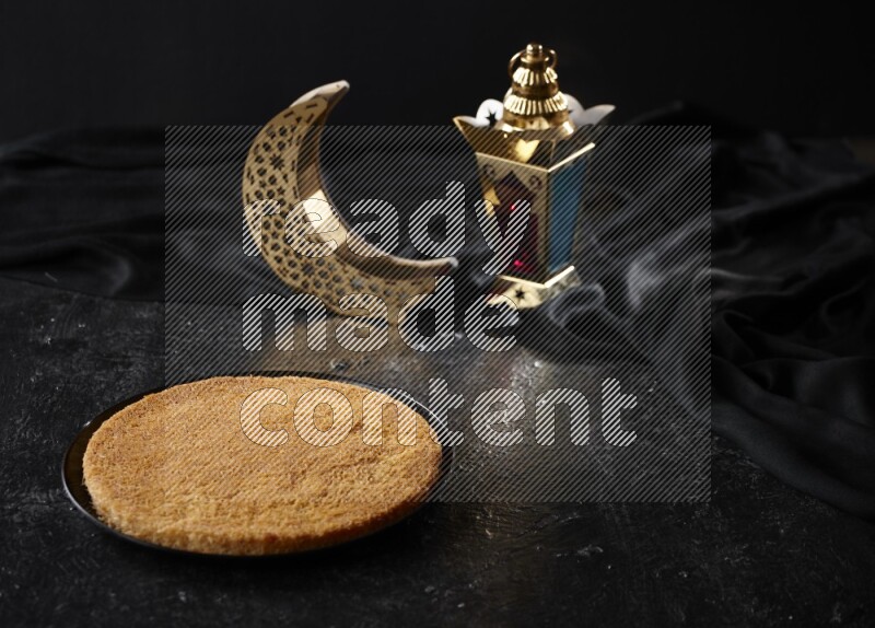 كنافة مع فوانيس علي خلفية سوداء خشبية