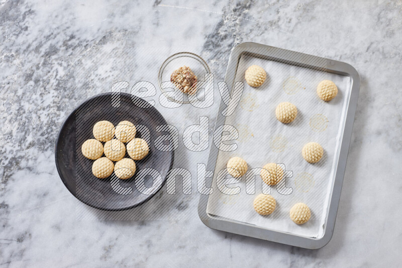 كحك خطوة بخطوة بمكوناته سمن، سكر، دقيق، سمسم، خميرة، ماء ونكهة الكحك على خلفية رخام رمادي