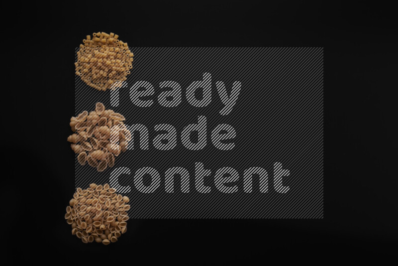 Different pasta types in 3 bunches on black background