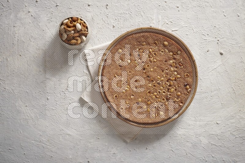 بسبوسة مع المكسرات علي خلفية بيضاء خشبية