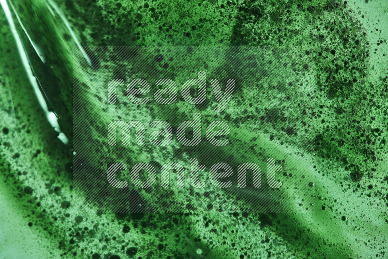 Close-ups of abstract green watercolor drops on oil Surface on green background