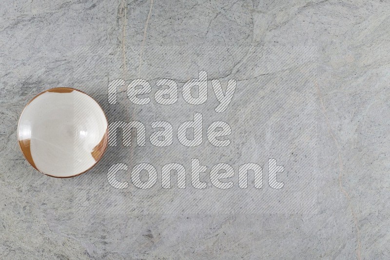 Top View Shot Of A Multicolored Pottery Plate On Grey Marble Flooring