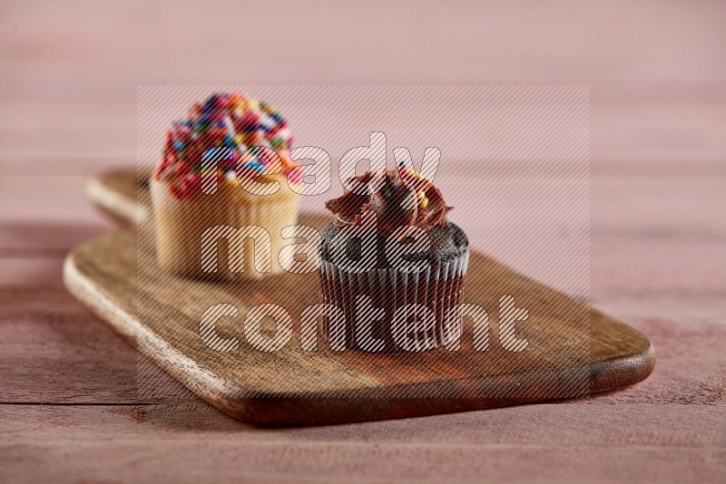 Chocolate mini cupcake topped with chocolate cream on a wooden board