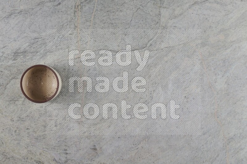 وعاء فخاري متعدد الألوان على خلفية من الرخام الرمادي