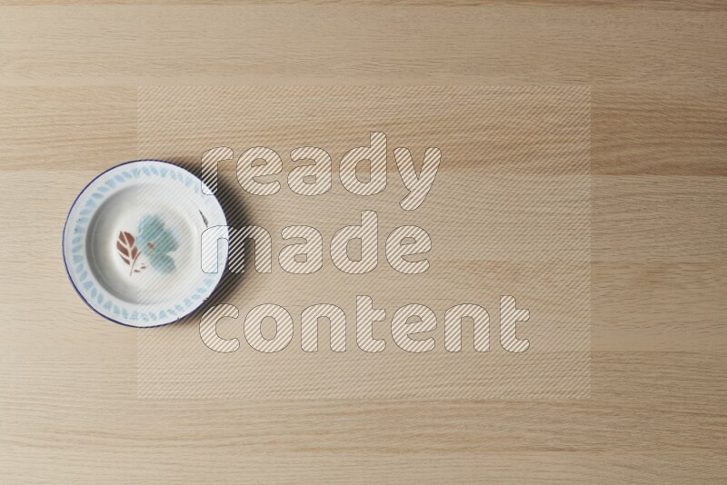 صحن معدني عتيق على خلفية خشبية فاتحة