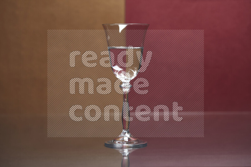 The image features a clear glassware filled with water, set against brown and dark red background