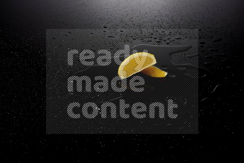 Lemon wedges with water drops, and droplets on black background