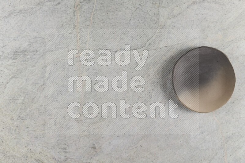 A multicolored pottery plate on grey marble background