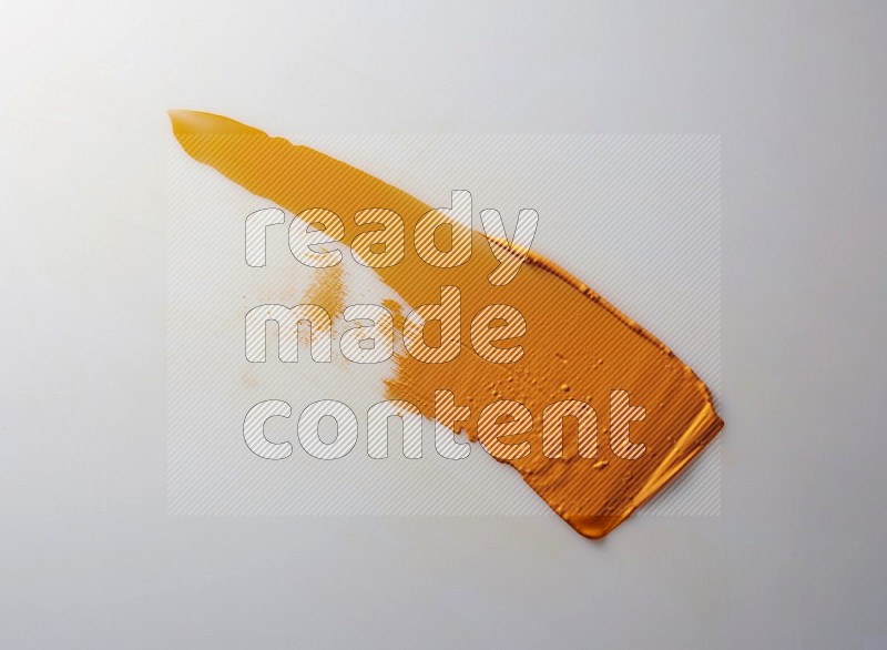 An orange straight painting knife stroke on white background