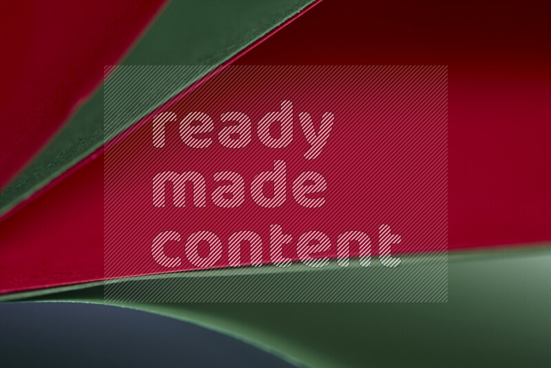 An abstract art showing red and green paper sheets arranged in an overlapping curves