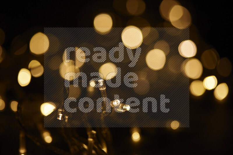 Light bulbs glowing against backdrop of golden bokeh