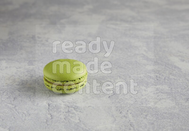 45º Shot of Yellow Lime macaron on white  marble background