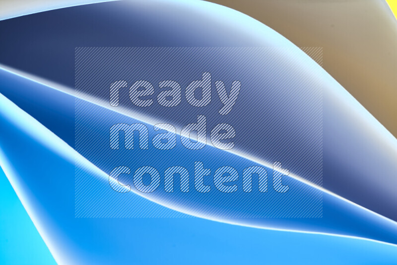 هذه الصورة تعرض تكوين فن الورق التجريدي مع منحنيات ورقية بتدرجات اللون الأزرق والأصفر المكونه بواسطة الضوء الملون