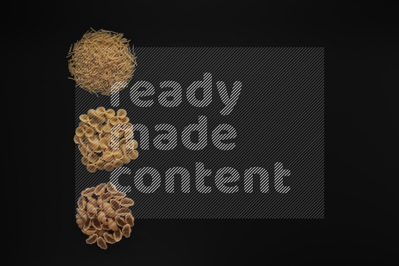 Different pasta types in 3 bunches on black background