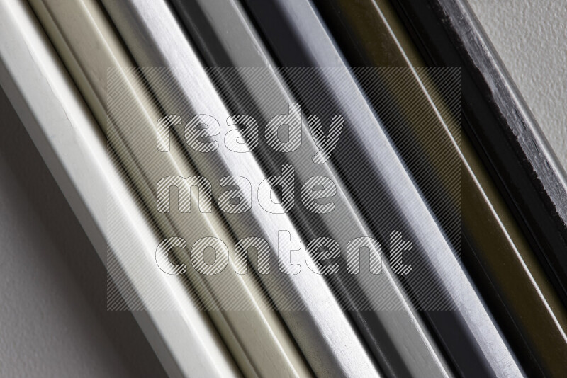 مجموعة من أقلام الرصاص الملونة مرتبة لتعرض تدرجا من اللون الأبيض والرمادي والأسود علي خلفية رمادية