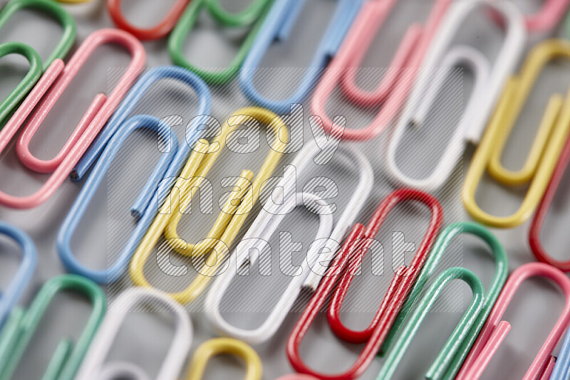 Multicolored paper clips isolated on a grey background