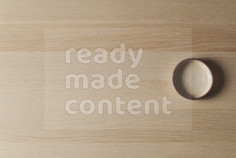 وعاء فرن فخاري باللون البيج على خلفية خشبية فاتحة