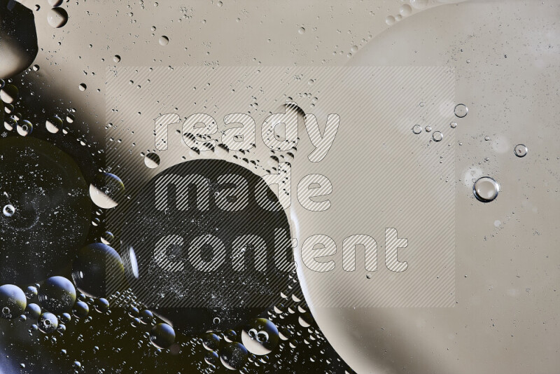 لقطات مقربة لفقاعات من الزيت على سطح الماء باللون الأسود والبيج