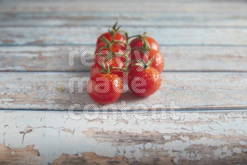 Red cherry tomato vein on a textured blue wooden background 45 degree