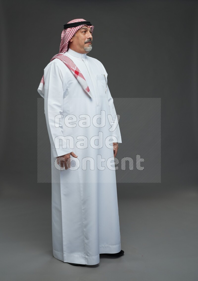 Saudi man with shomag Standing Interacting with the camera on gray background
