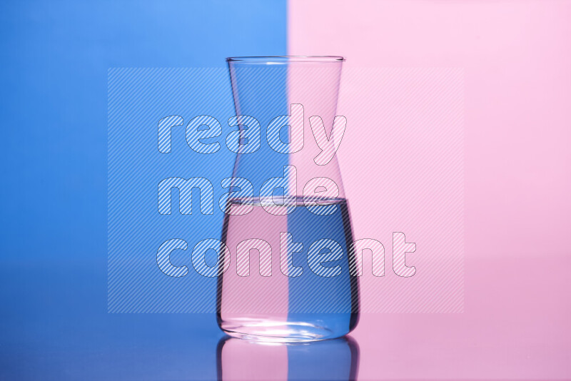 The image features a clear glassware filled with water, set against blue and rose background