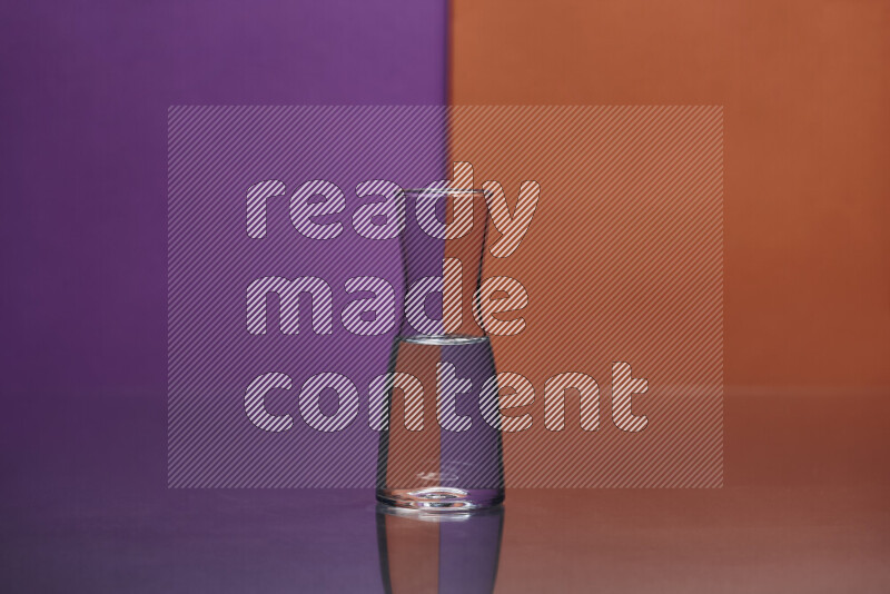 The image features a clear glassware filled with water, set against purple and dark orange background