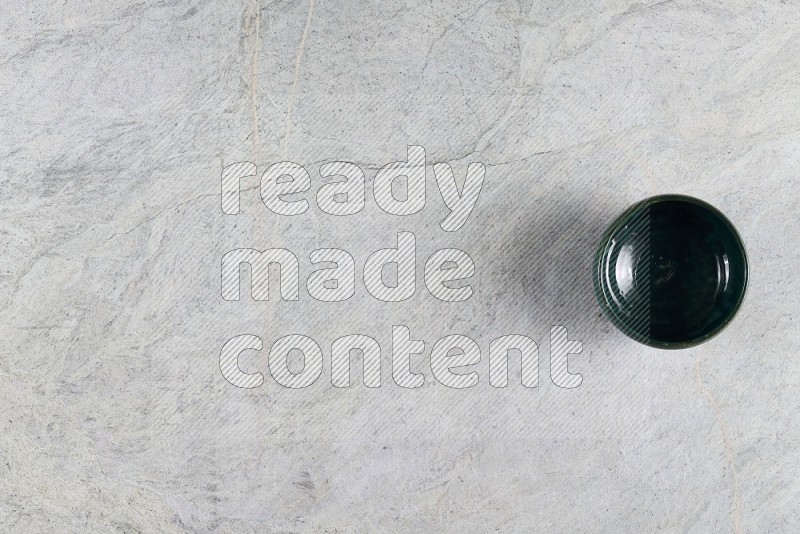 Top View Shot Of A Dark Green Pottery Bowl On Grey Marble Flooring
