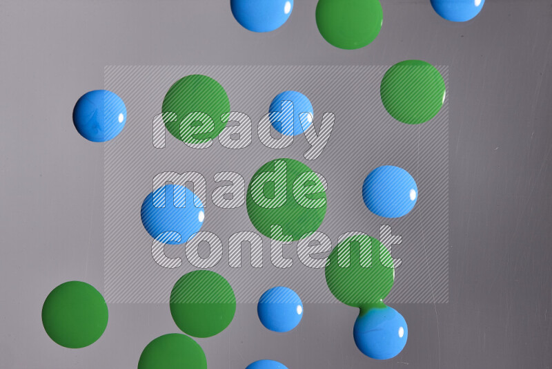 Close-ups of abstract blue and green paint droplets on the surface