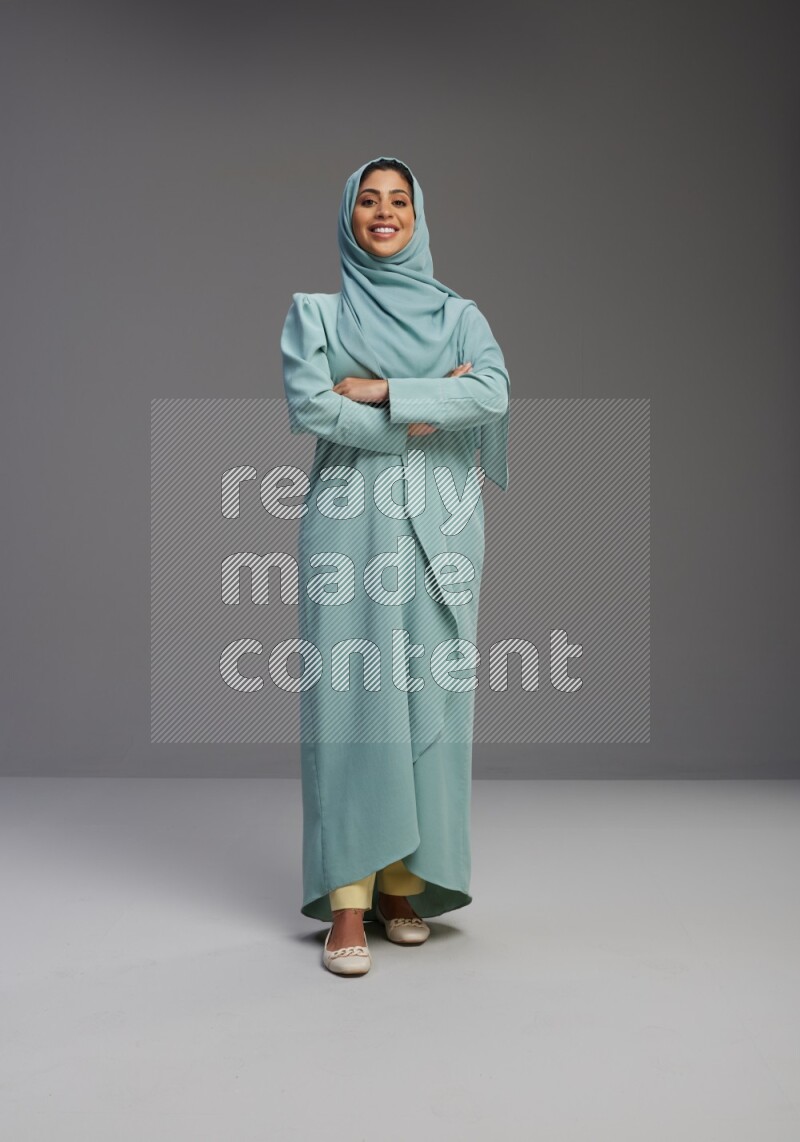 Saudi Woman wearing Abaya standing with crossed arms on Gray background
