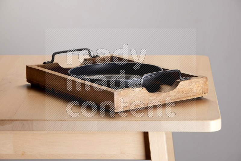 black plate on a light colored rectangular wooden tray with handles