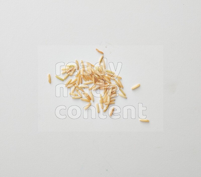 Top-view shot of long grain brown rice on white background