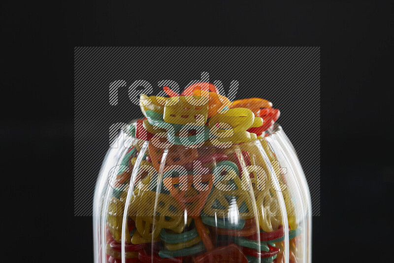 Snacks in a glass jar on black background