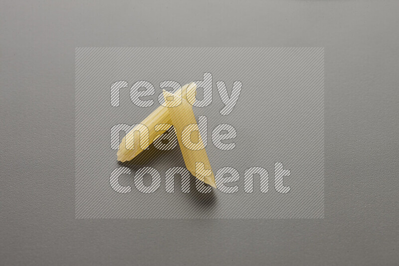 Mini penne pasta on grey background