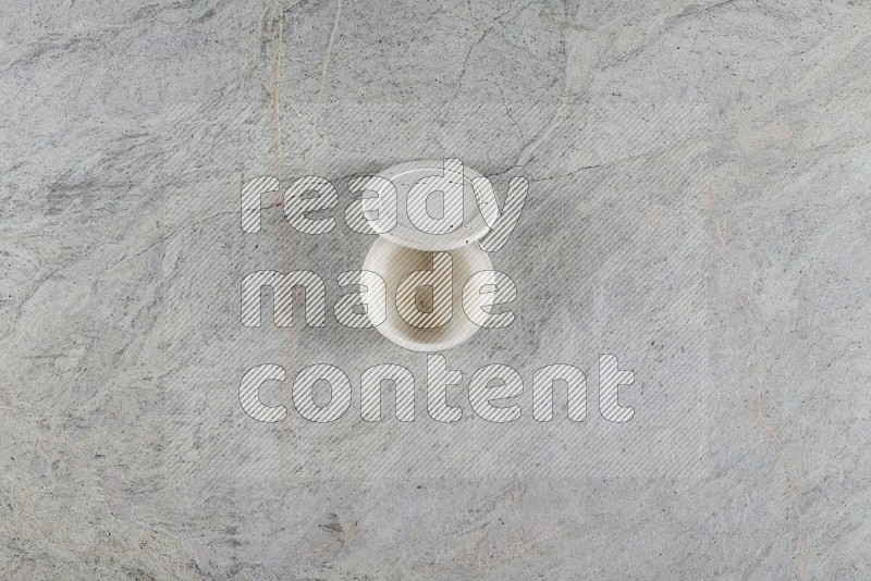 Top View Shot Of A Multicolored Pottery Cup On Grey Marble Flooring