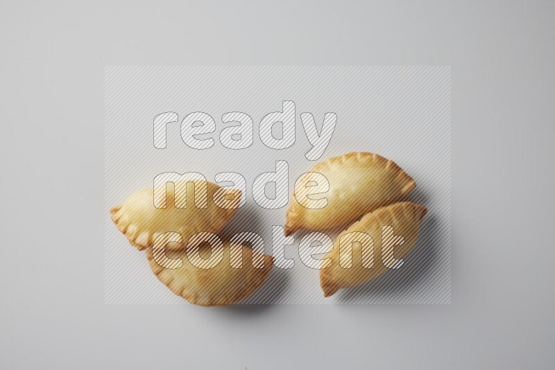 Four fried sambosa from a top angle on a white background