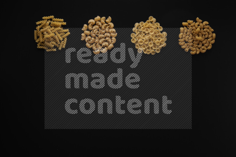 Different pasta types in 4 bunches on black background
