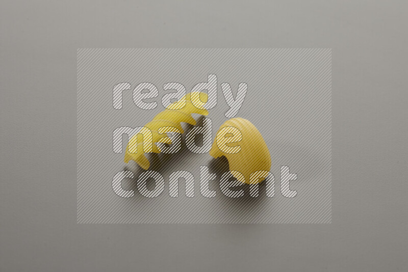 Pipe pasta with other types of pasta on grey background