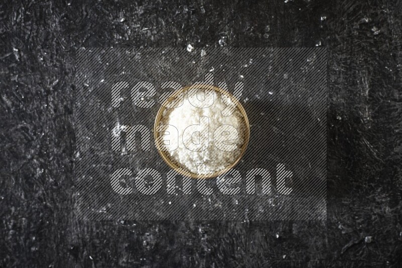 Dried fruits in a metal bowl in a dark setup