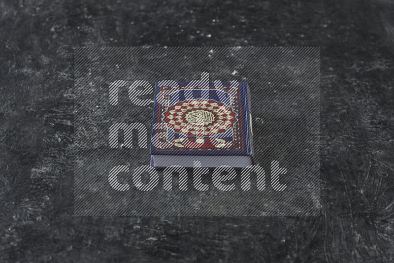 Quran with a prayer beads on textured black background