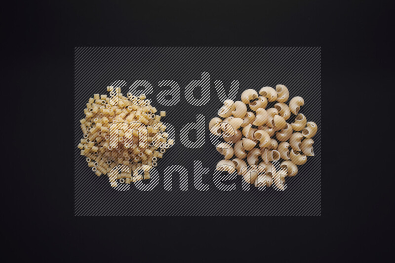 Different pasta types in bunches on black background