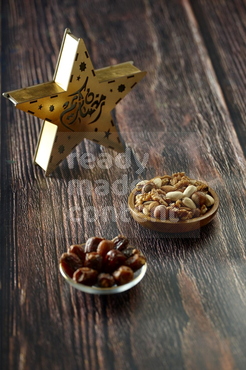 A star lantern with drinks, dates, nuts, prayer beads and quran on brown wooden background