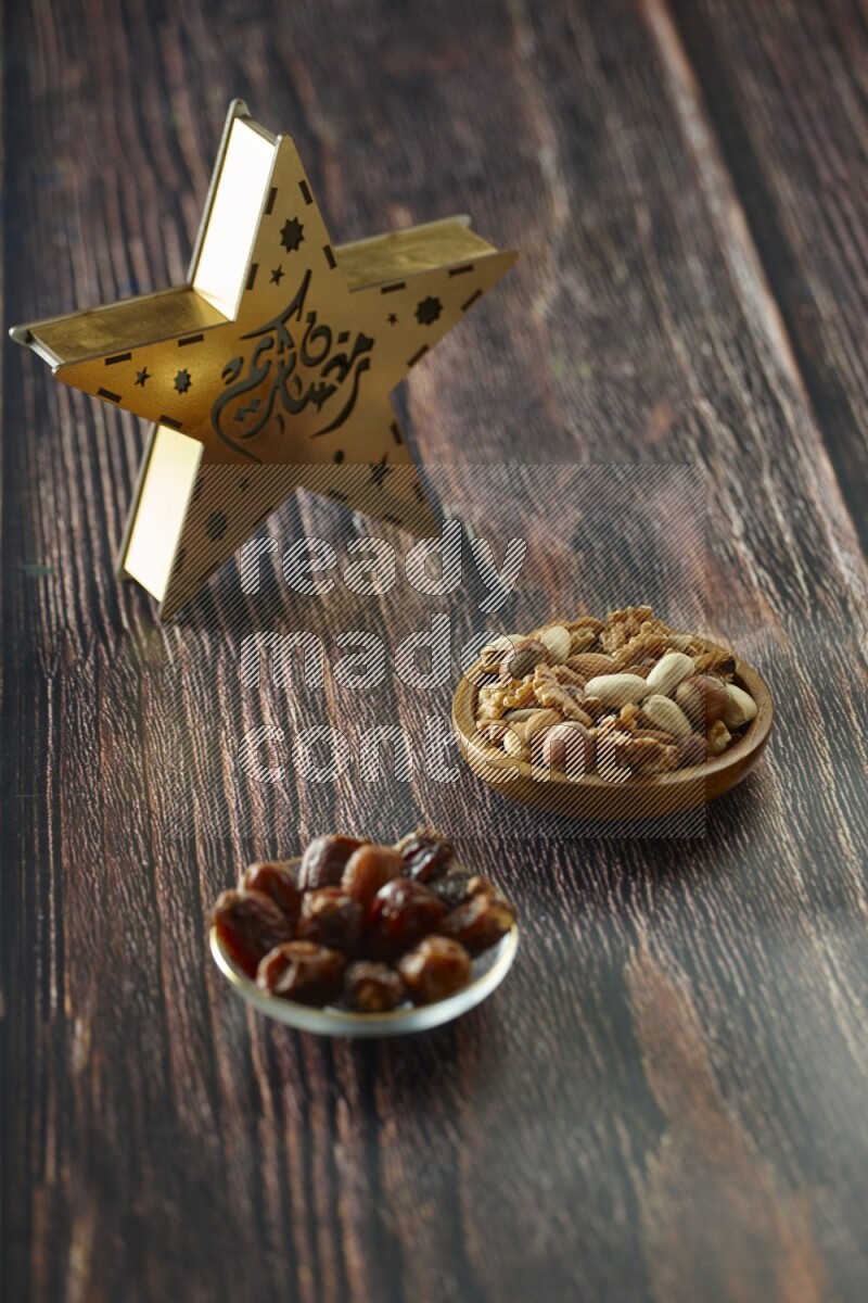 A wooden golden star lantern with different drinks, dates, nuts, prayer beads and quran on brown wooden background