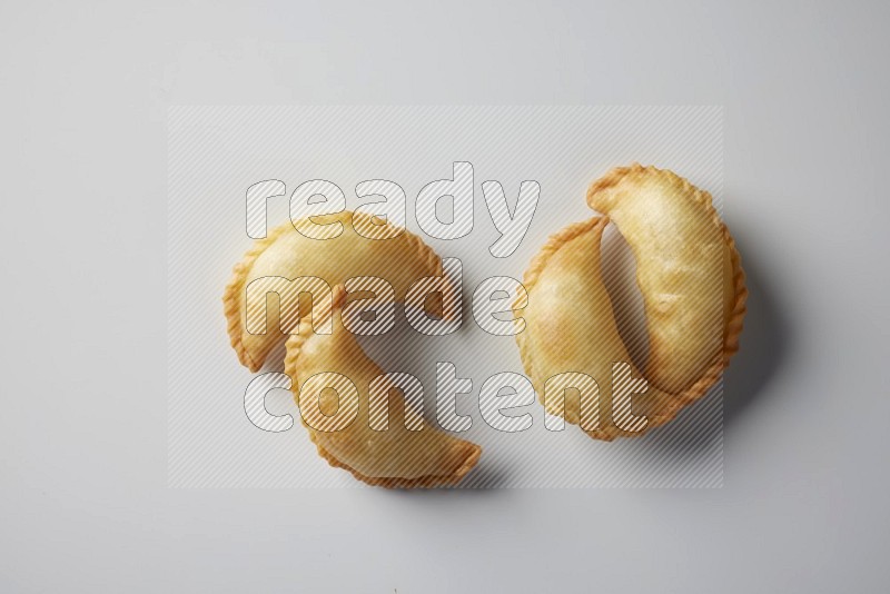 Four fried sambosa from a top angle on a white background