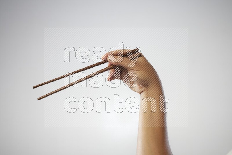 Male Hand Holding Chop Stick on white background